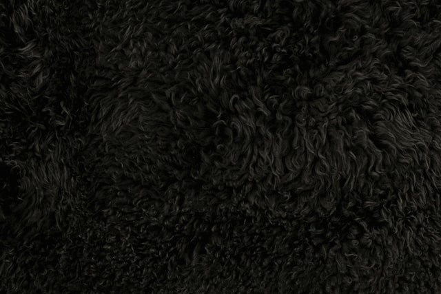 Close up of black long wool sheepskin rug 